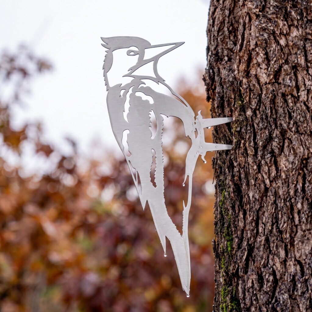 Woodpecker Stake set flush against a tree trunk in autumn